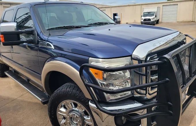 Dark blue Ford F-250 pickup truck with grille guard in parking lot
