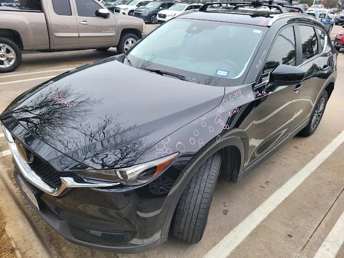 Black SUV with tree reflection and decorative doodles parked in lot