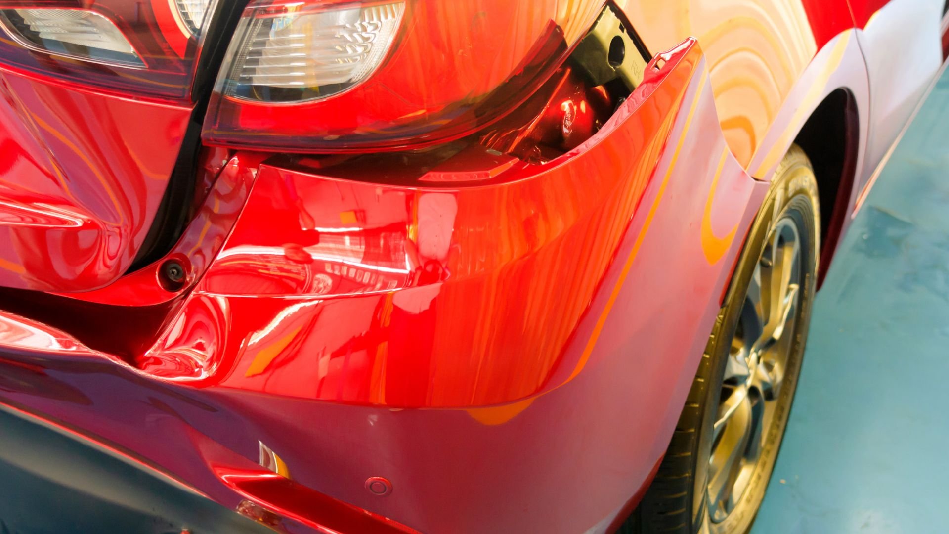 Shiny red car rear with gold wheel, close-up of curves and taillight