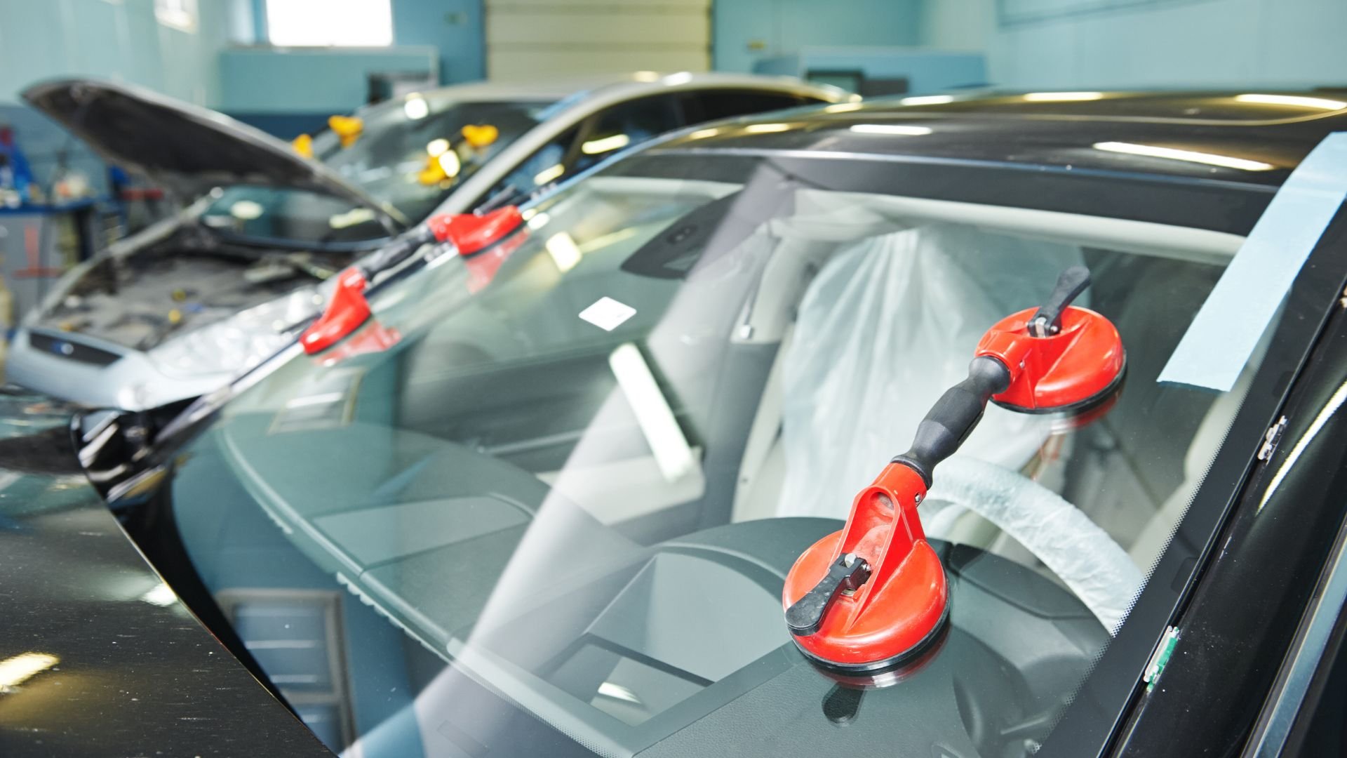 Red suction cups holding windshield during auto glass replacement